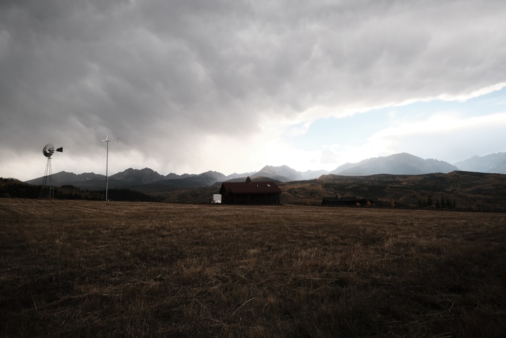 a field with a barn and a light pole in the distance