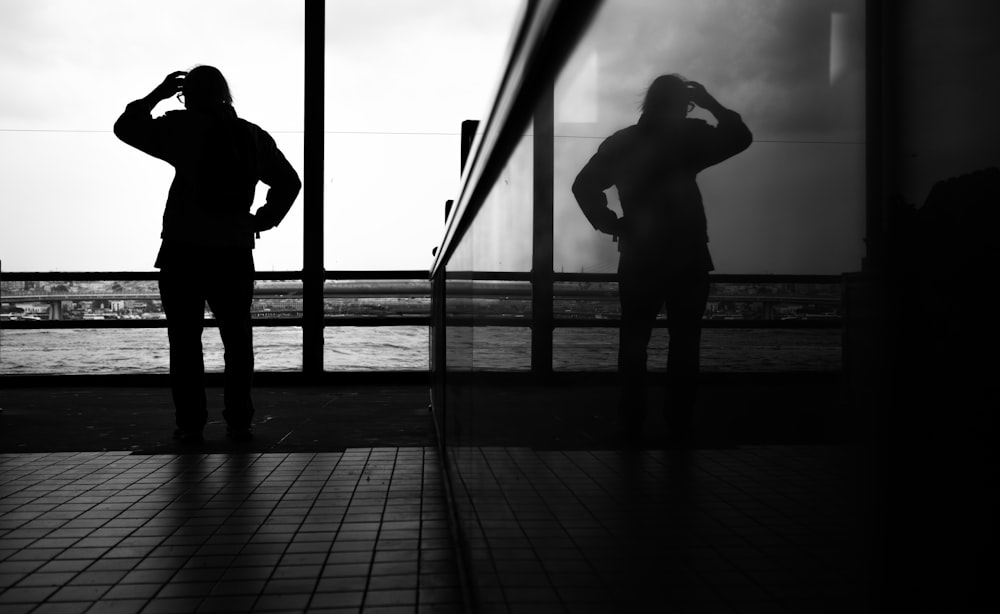 a man standing in front of a window next to a tall building