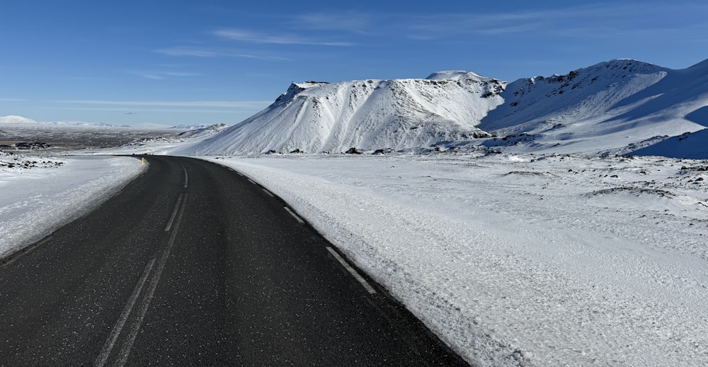 una strada innevata con una montagna sullo sfondo