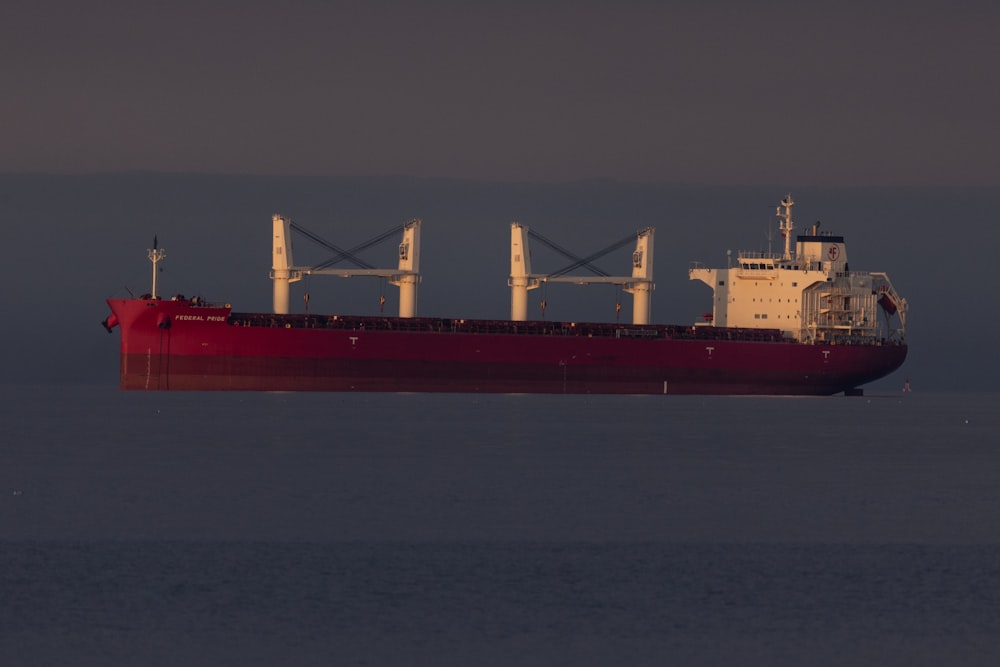 a large red boat floating on top of a body of water