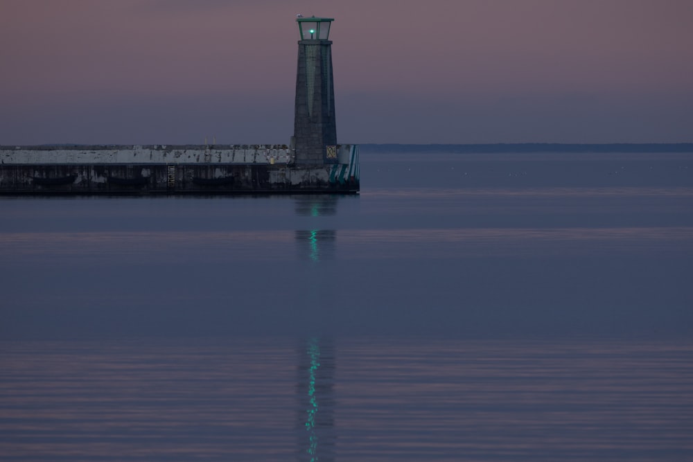 a clock tower sitting on the end of a pier