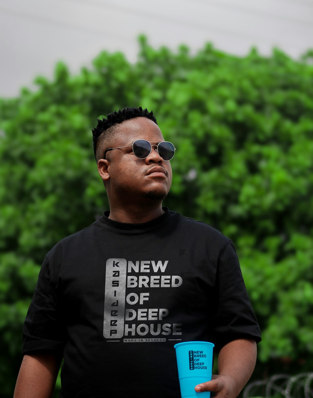 a man in a black shirt holding a blue cup