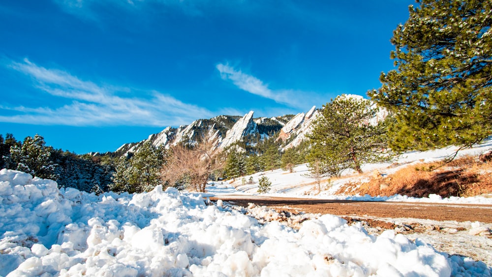 a snow covered road with a mountain in the background