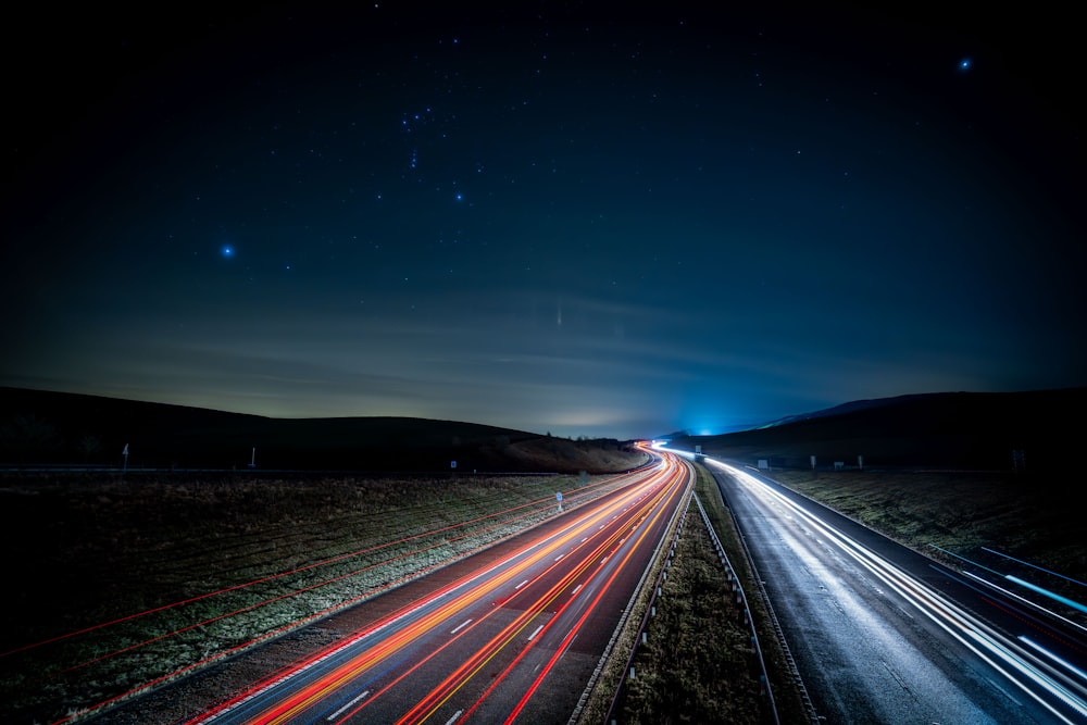 a long exposure photo of a highway at night