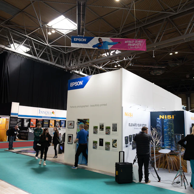 A group of people standing around an exhibition booth at a trade fair