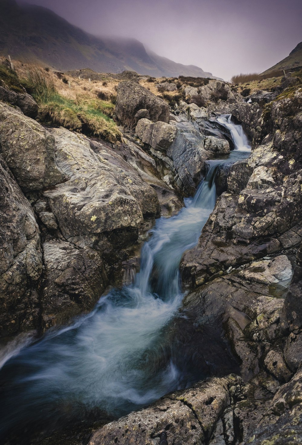 a small stream running through a rocky valley