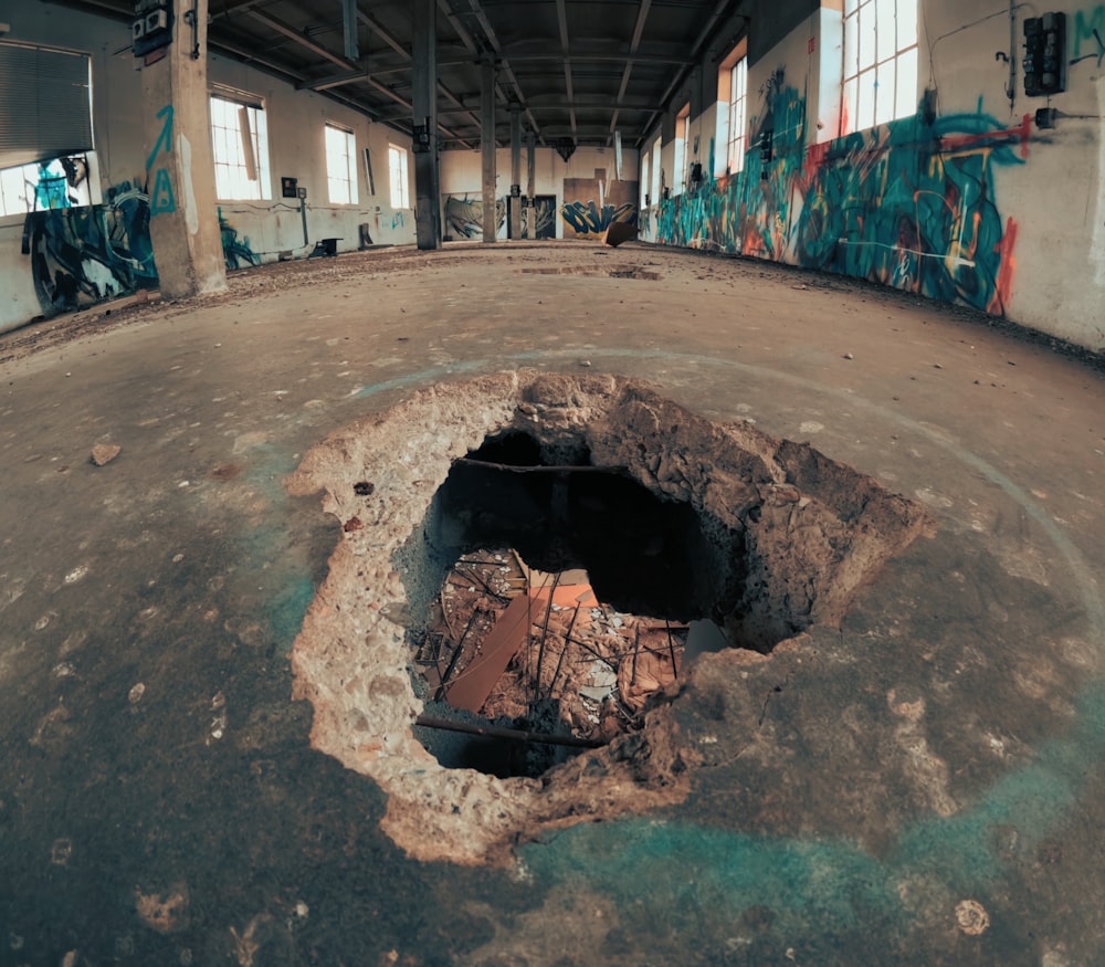 a hole in the ground with graffiti on it