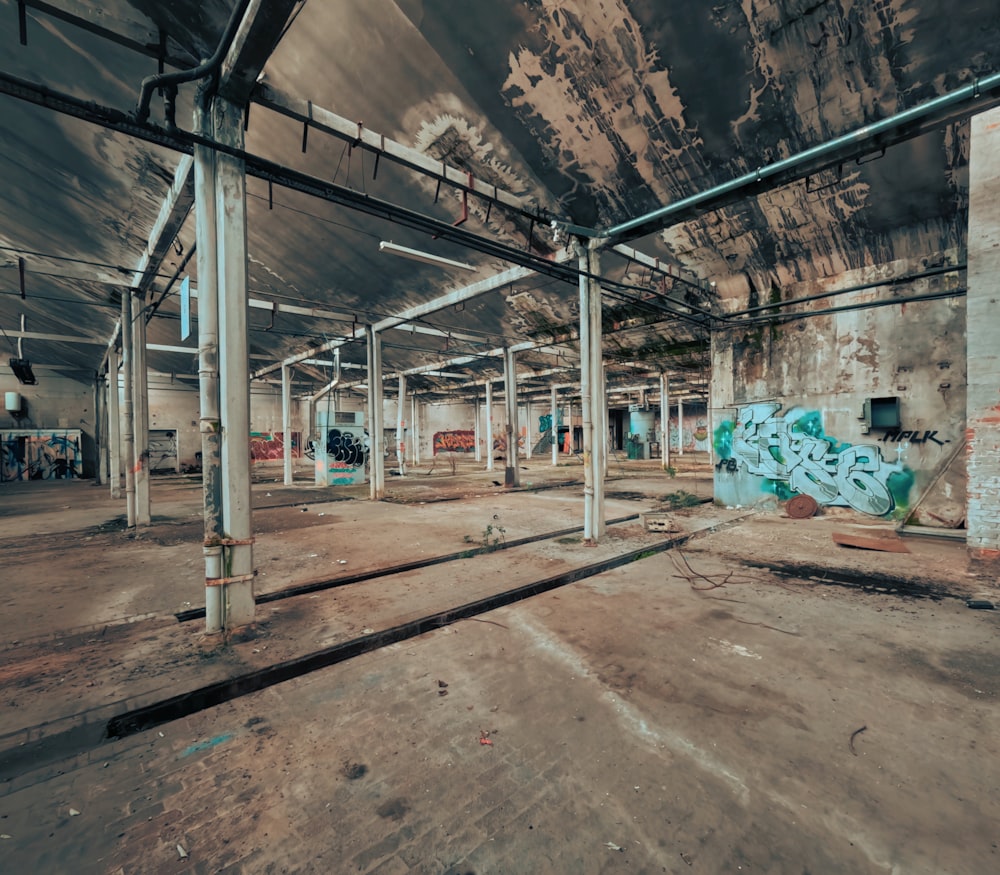 an empty warehouse with graffiti on the walls