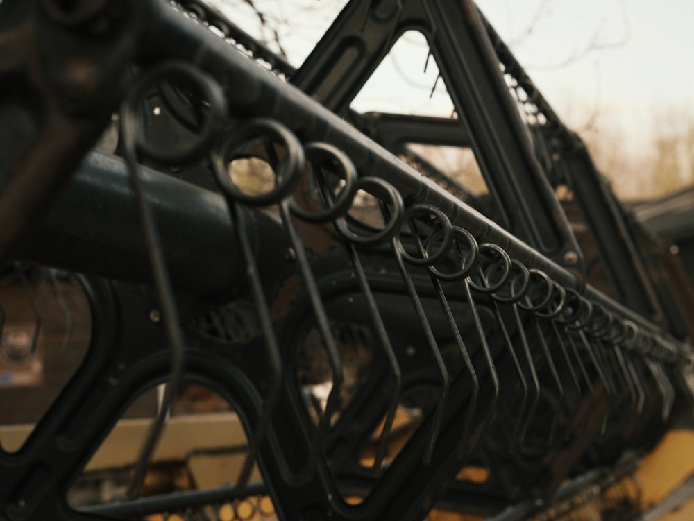 a close up of a metal fence with a building in the background