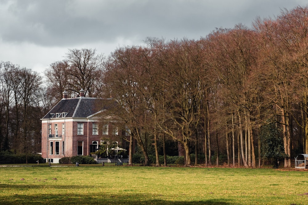 a house in a field with trees in the background