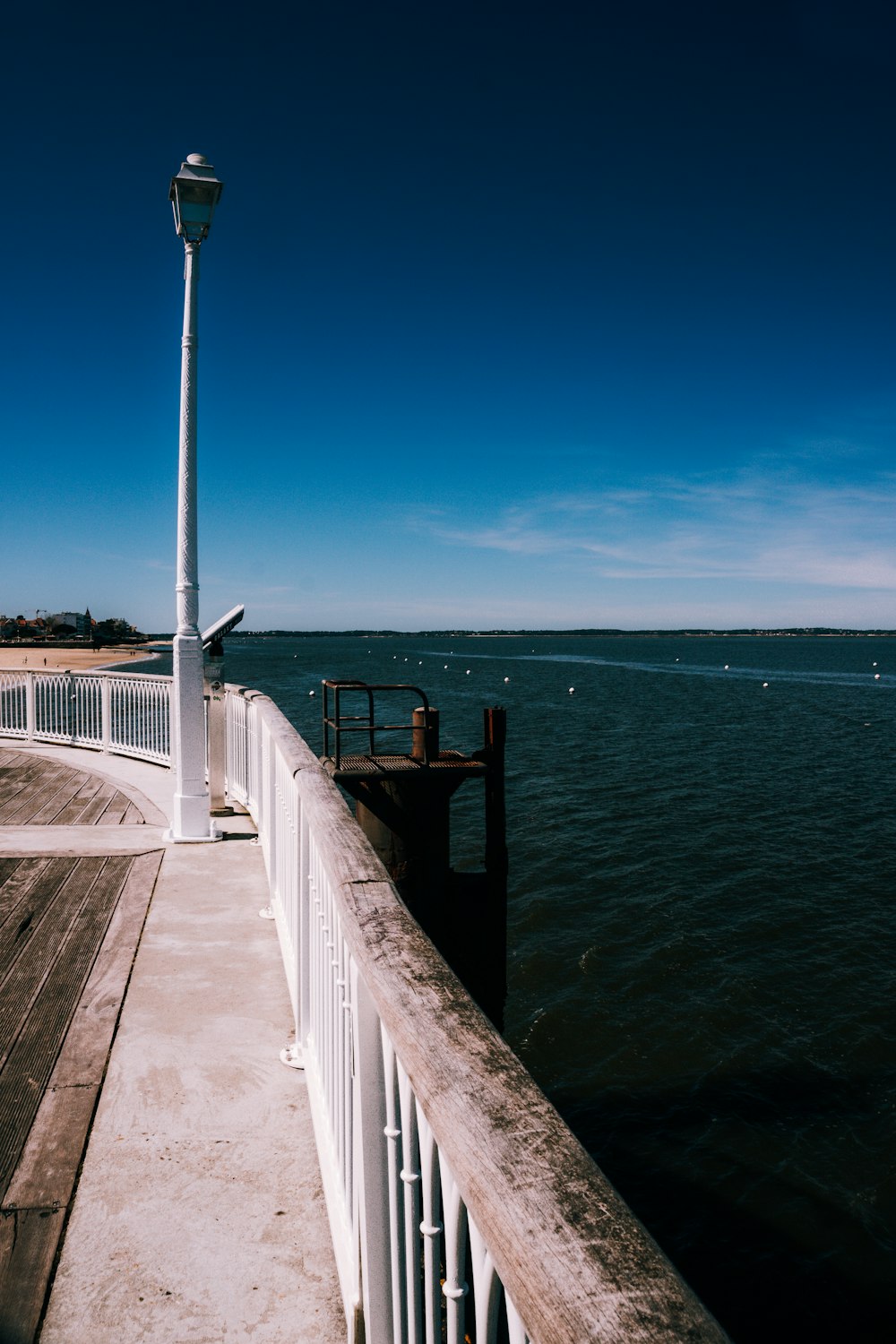 a pier with a light pole next to a body of water
