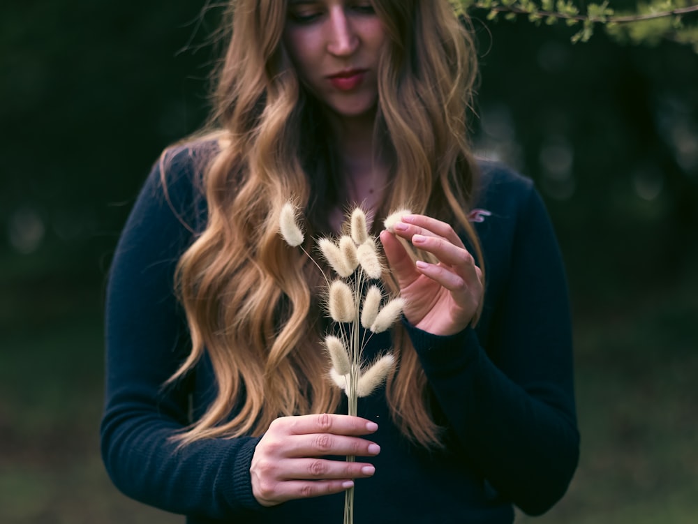 a woman holding a bunch of flowers in her hands