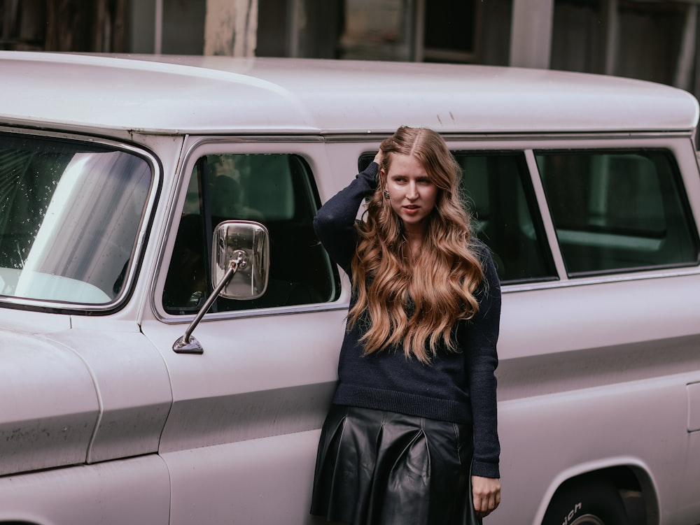 a woman standing next to a white van