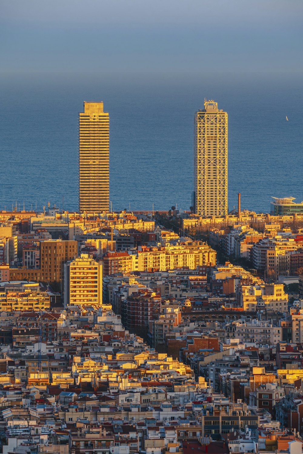 a view of a city with tall buildings and a body of water in the background