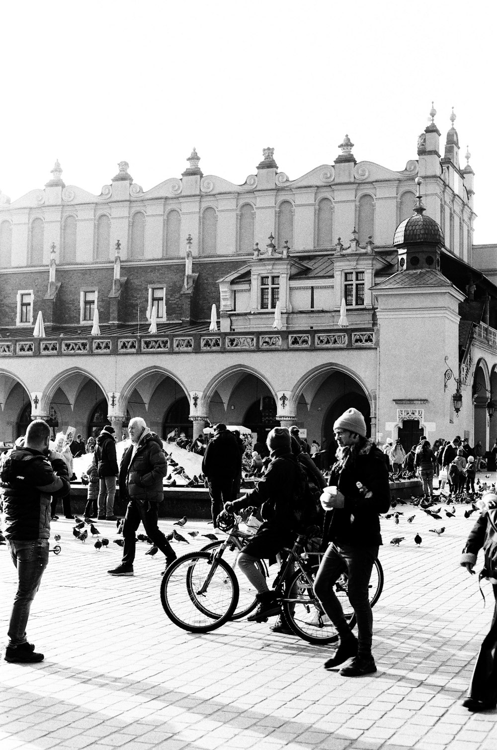 a black and white photo of people and bicycles