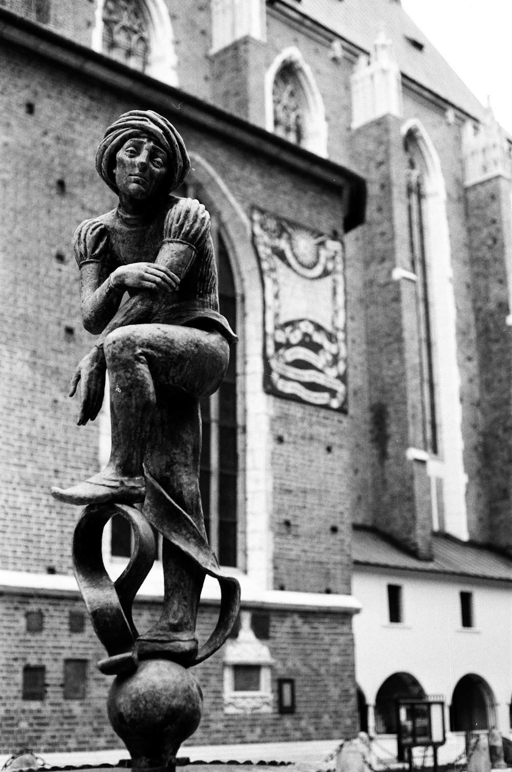 Una foto en blanco y negro de una estatua frente a un edificio