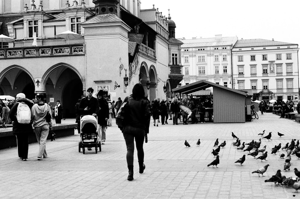 a black and white photo of people walking around a city