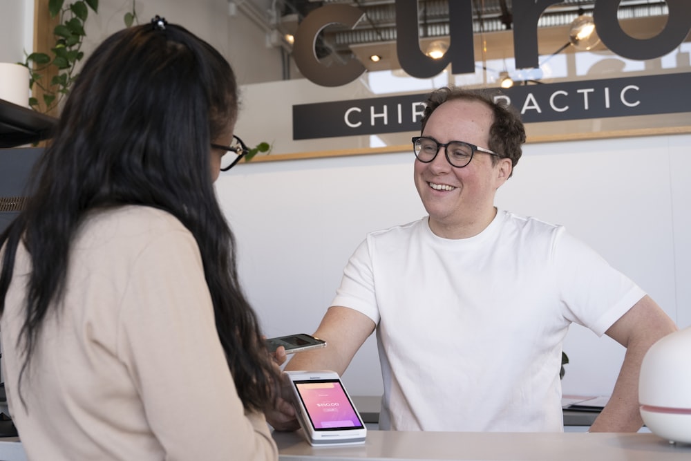 a man sitting at a desk talking to a woman