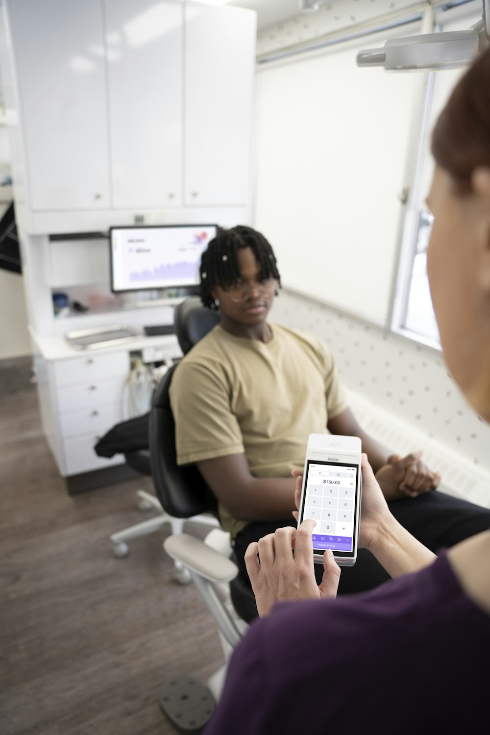 a woman sitting in a chair looking at a cell phone