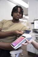 a person holding a credit card and a cell phone