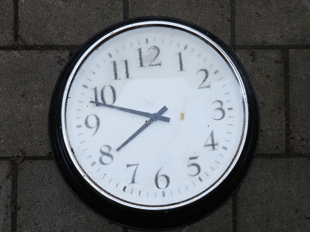 a close up of a clock on a sidewalk