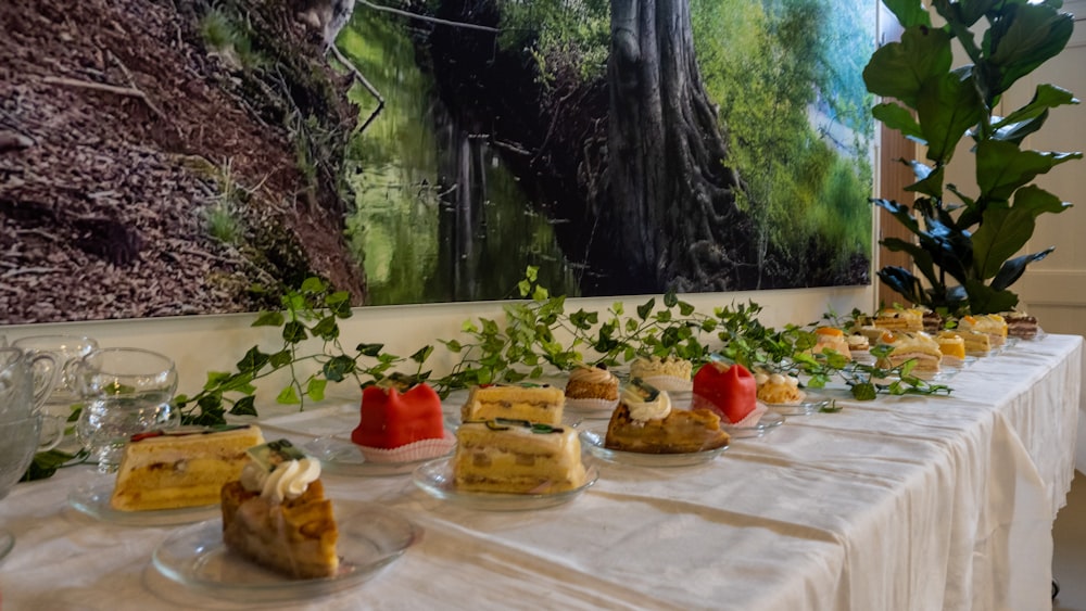 a table topped with plates of food next to a painting