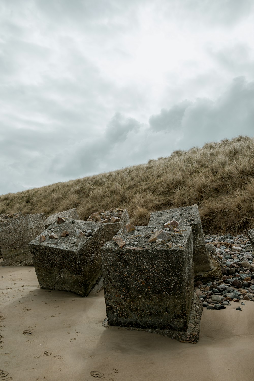 a group of rocks sitting on top of a sandy beach