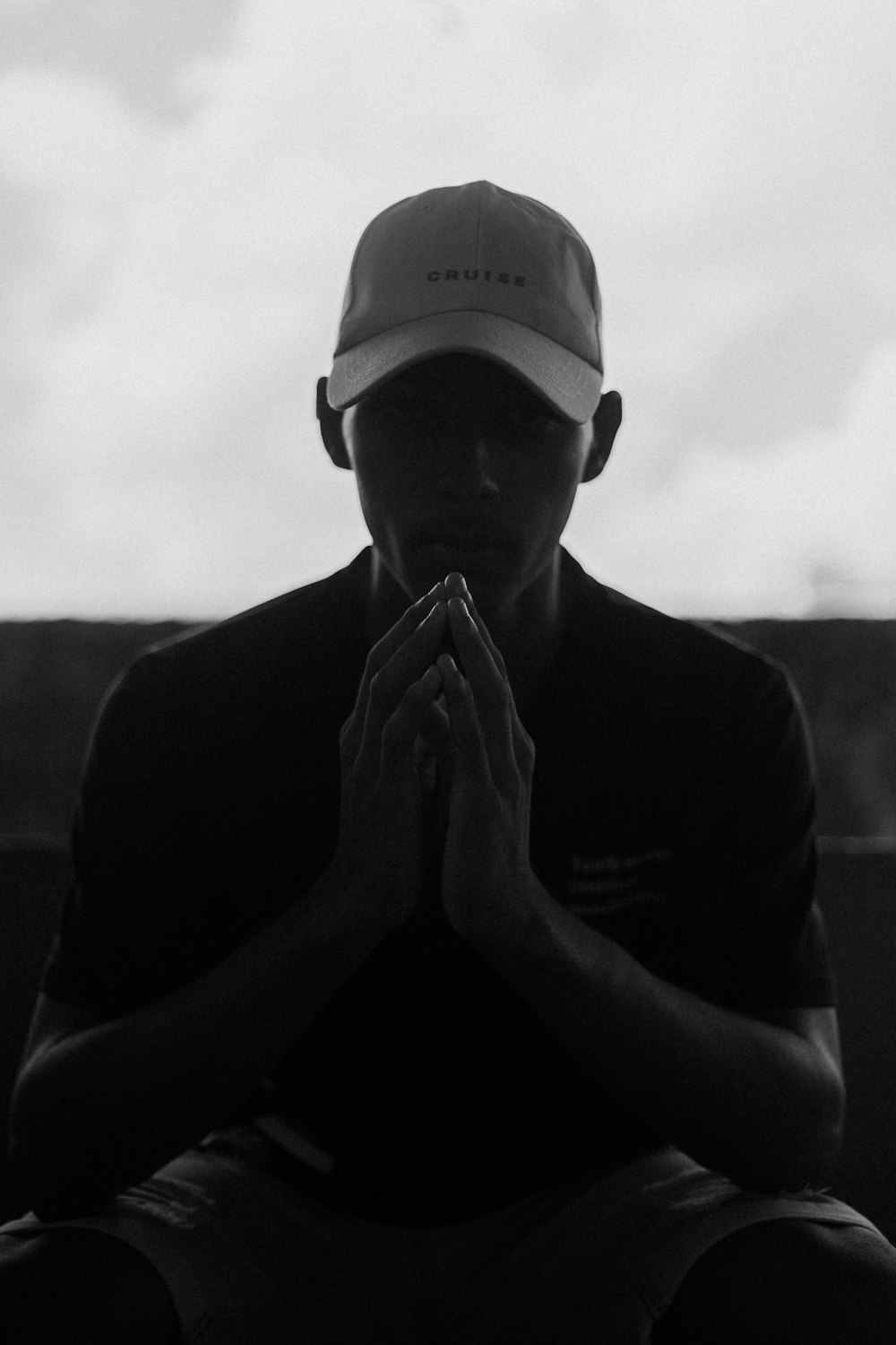 a black and white photo of a man praying