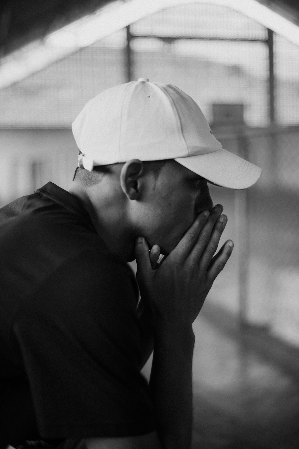 a black and white photo of a person wearing a hat