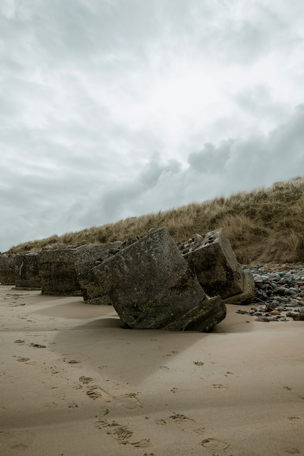 a large rock sitting on top of a sandy beach