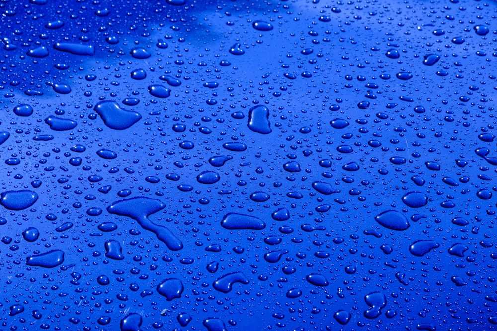 water drops on a blue surface with a blue sky in the background