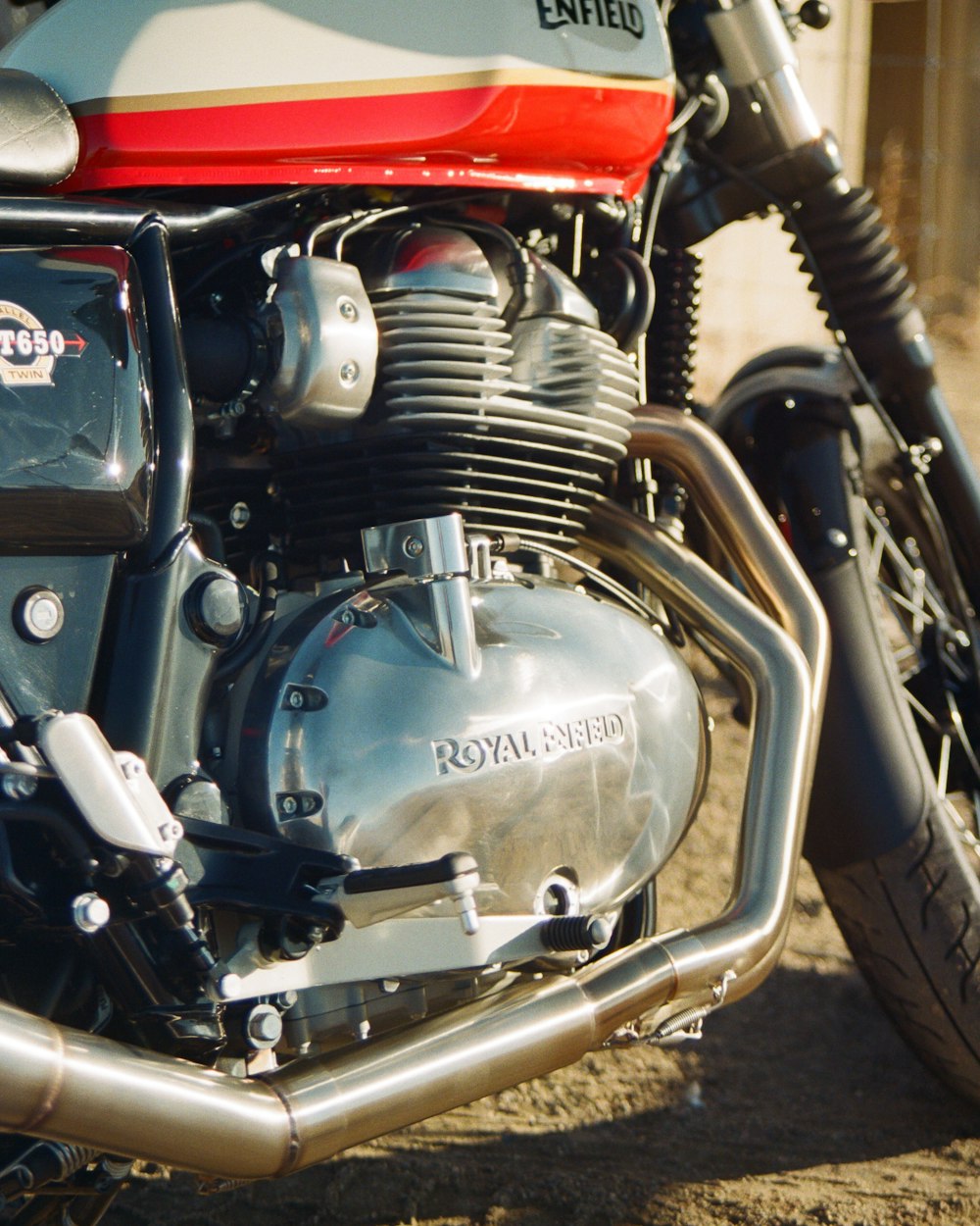 a close up of a motorcycle parked on a dirt road