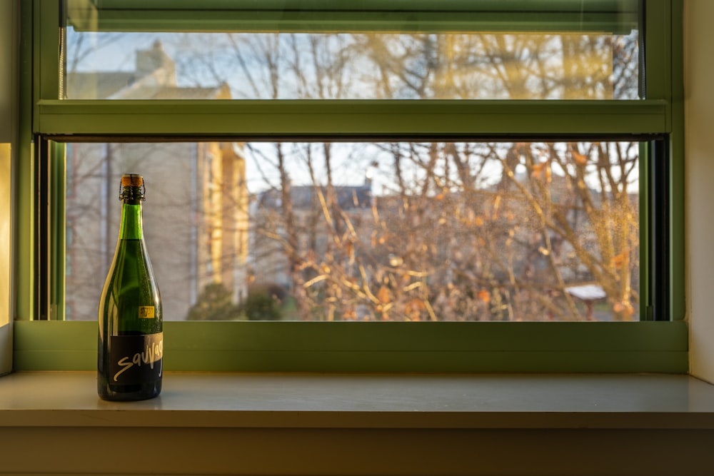 a bottle of beer sitting on a window sill