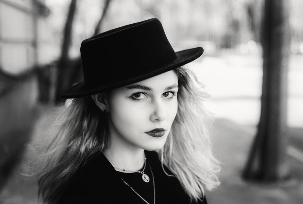 a woman wearing a black top hat and a necklace