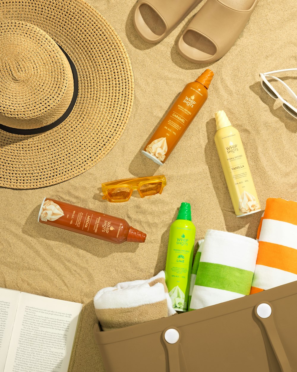 a beach scene with a hat, sunglasses, sunscreen, and other items