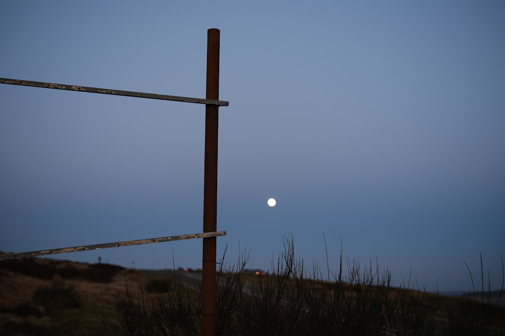 a full moon is seen behind a wooden fence