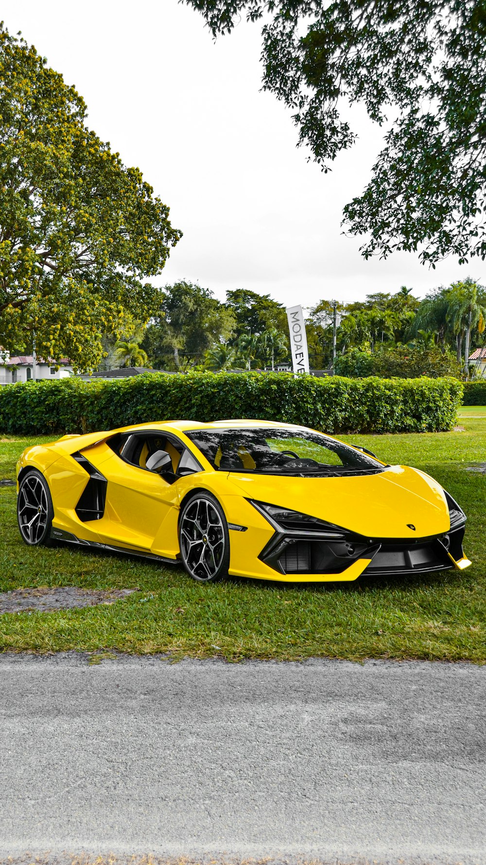 a yellow sports car parked in the grass