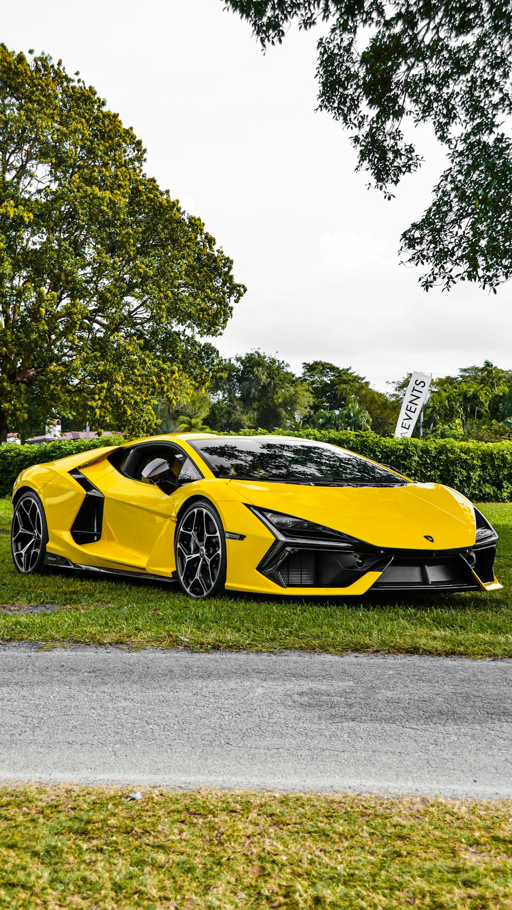 a yellow sports car parked on the side of the road