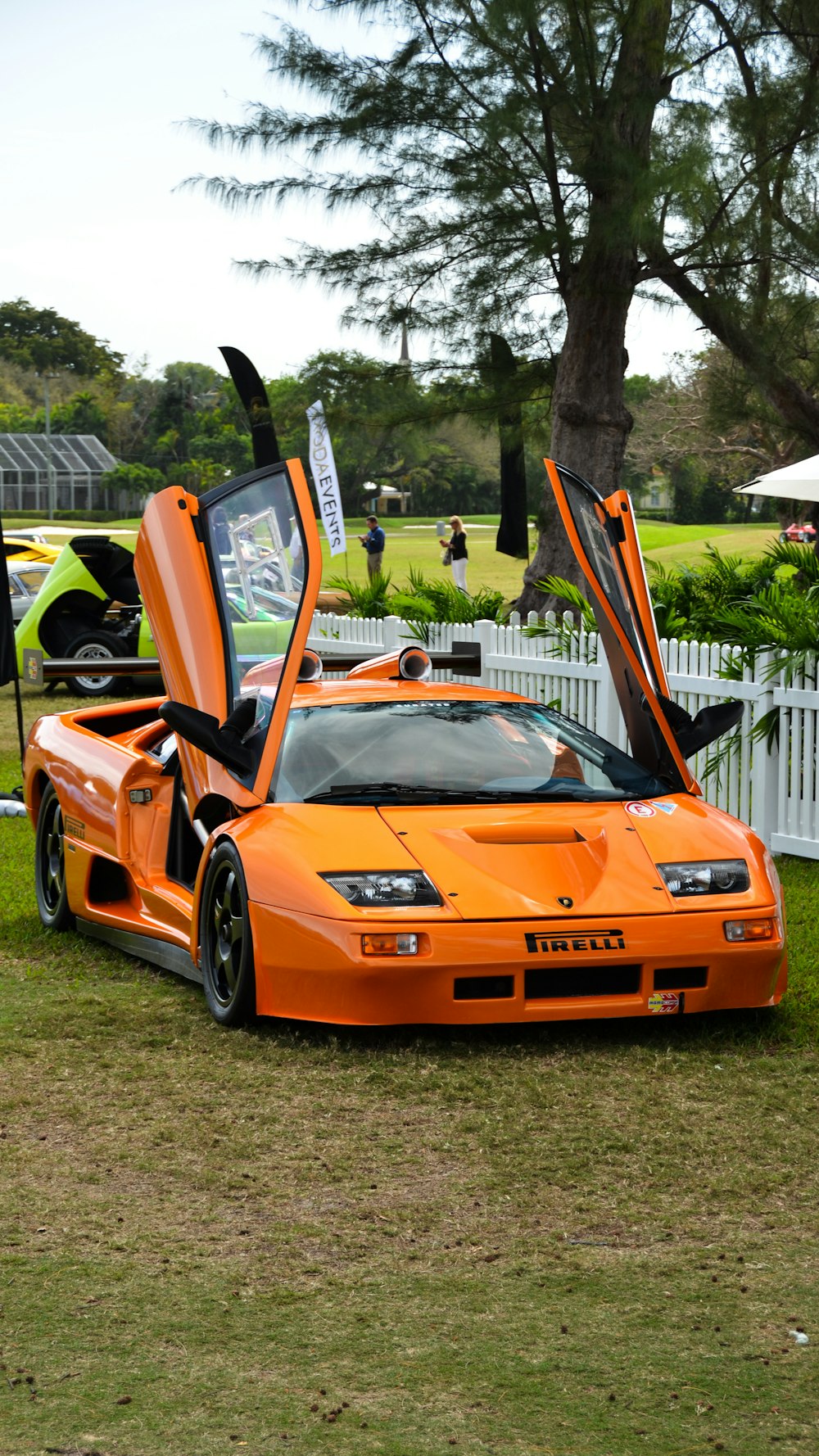 an orange sports car with its doors open