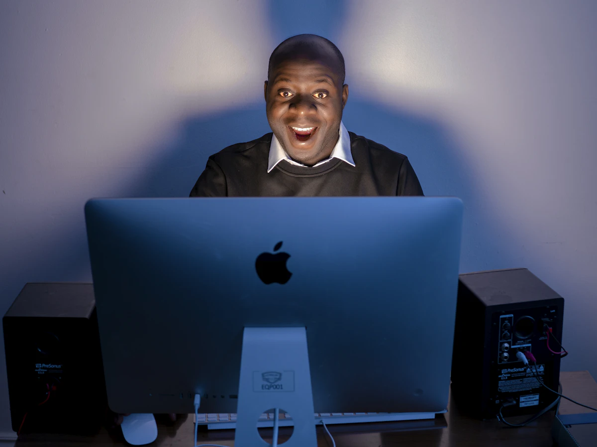 A man sitting in front of a computer on a desk