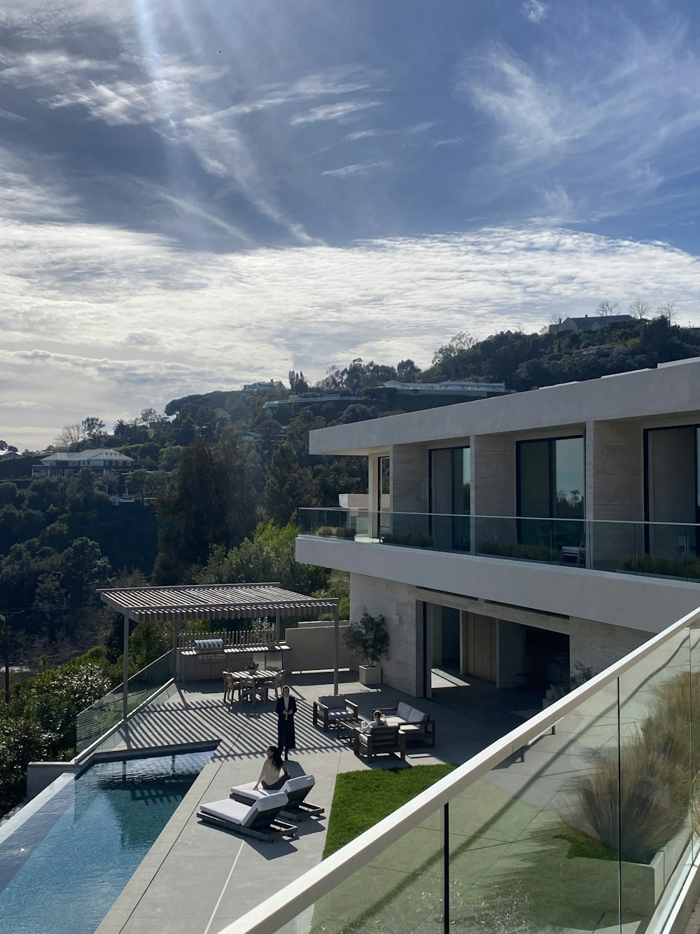 a person standing on a balcony next to a swimming pool