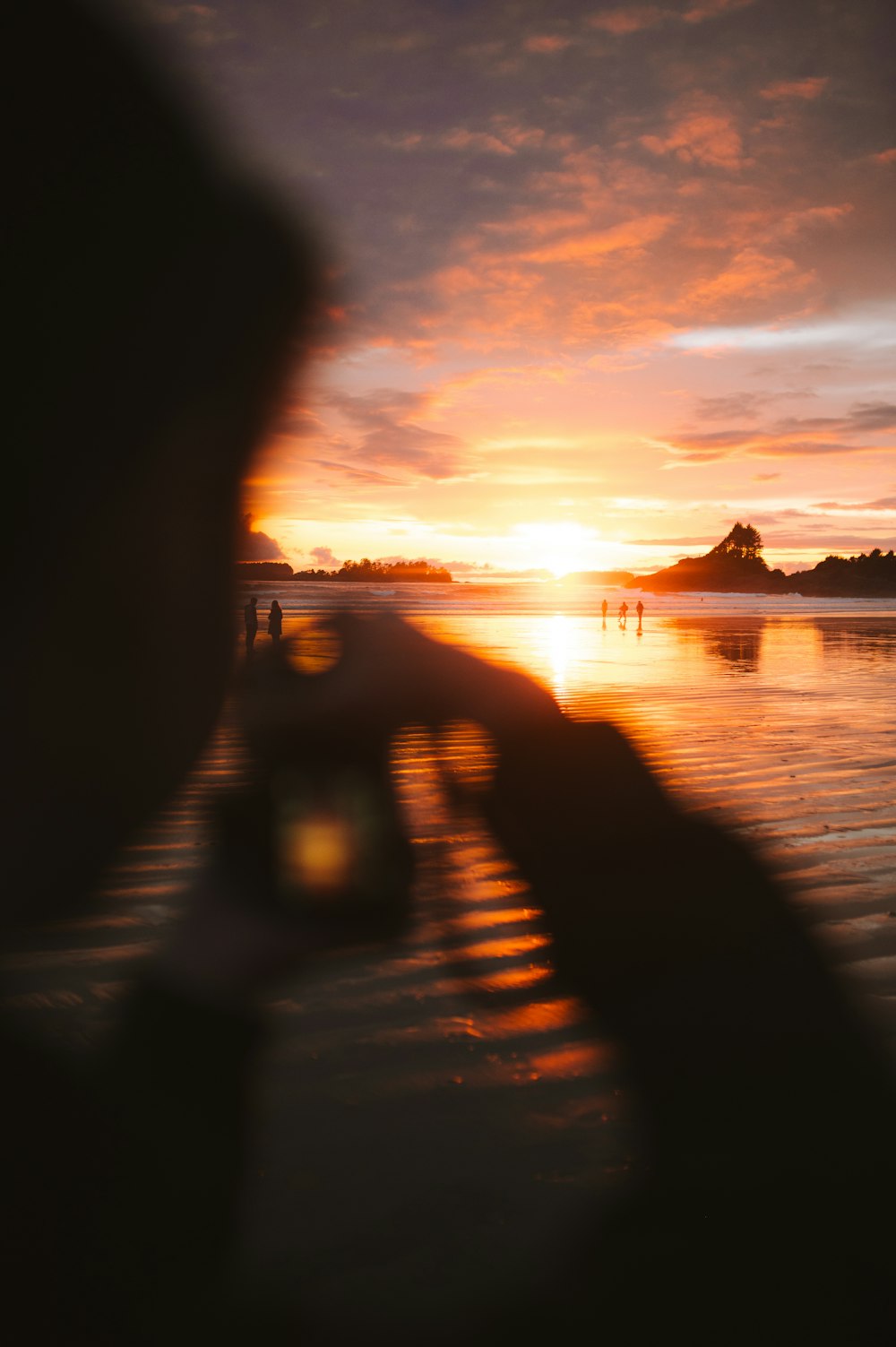 a person taking a picture of a sunset