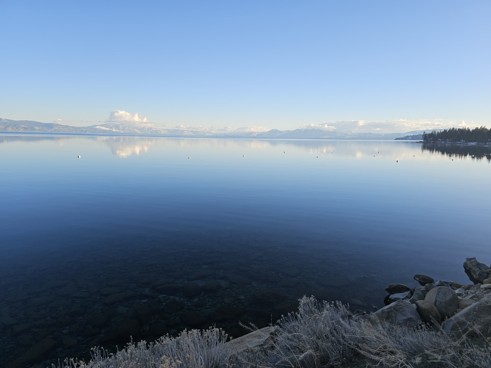 a large body of water surrounded by snow covered mountains