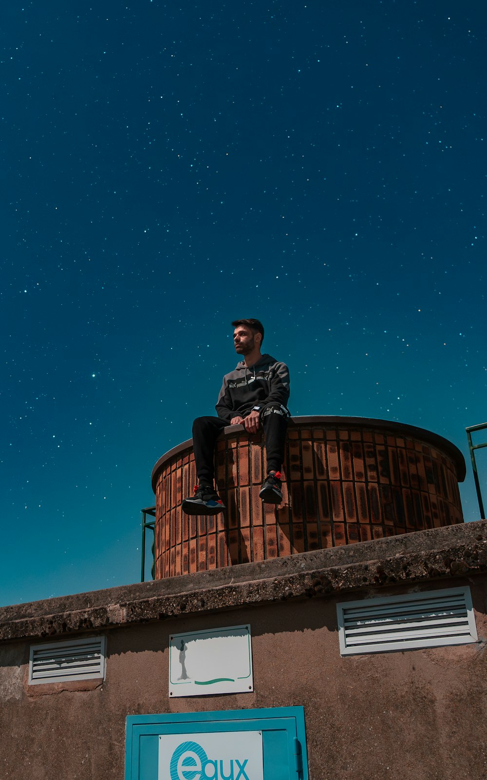 a man is sitting on top of a building