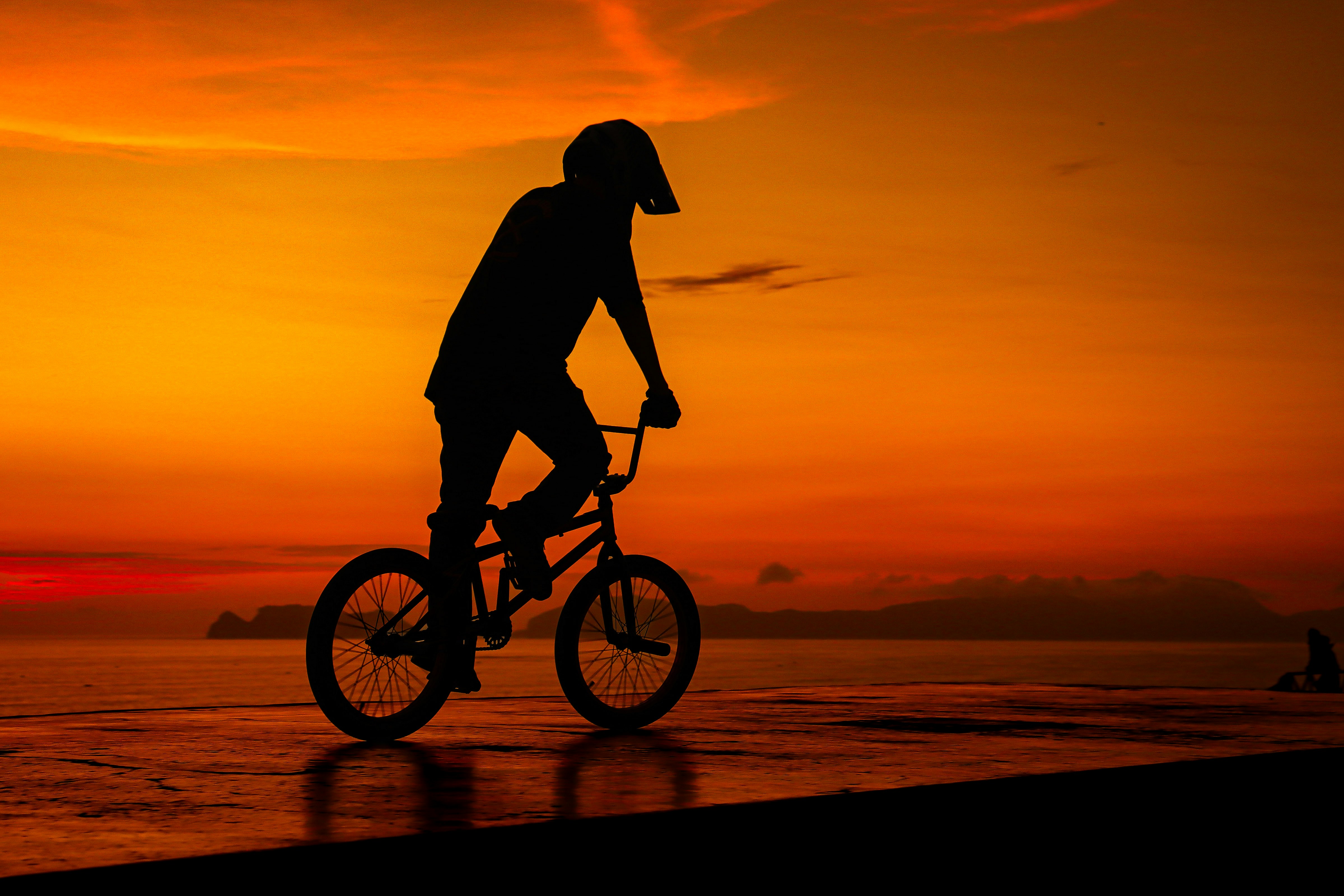 a man riding a bike on top of a beach