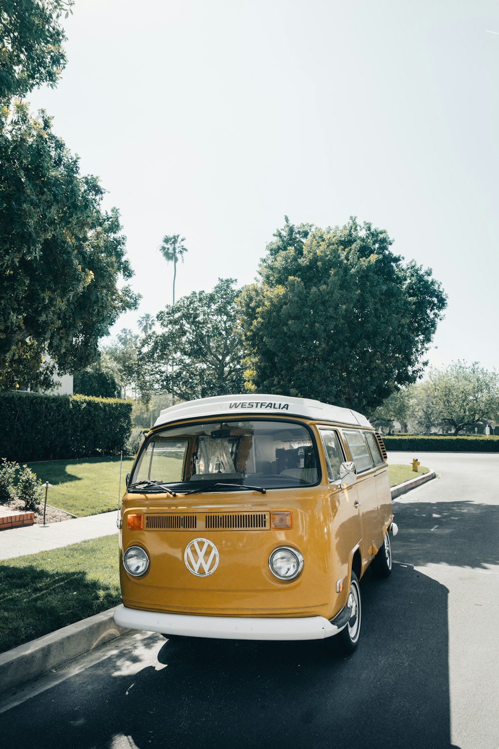 a yellow and white van driving down a street