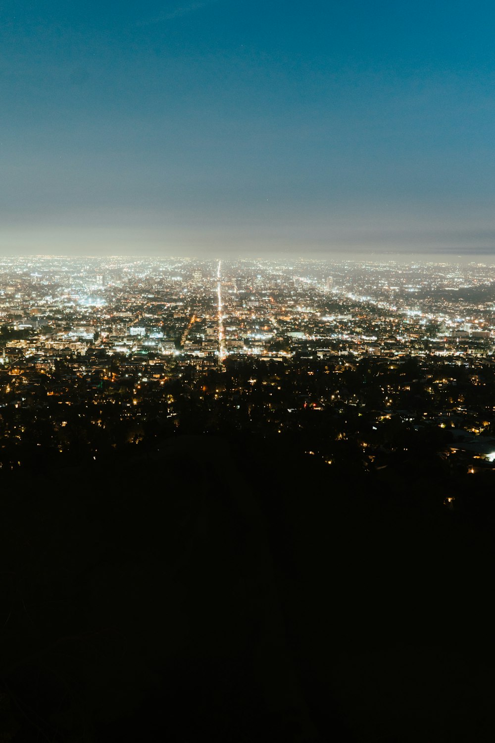 a view of a city at night from the top of a hill