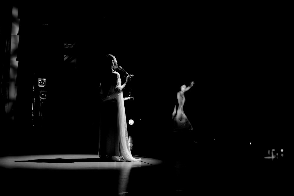 a black and white photo of a woman on stage