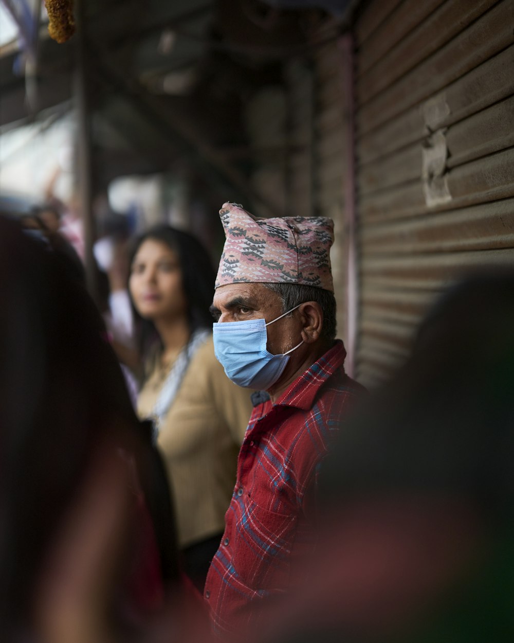 a man wearing a surgical mask and a plaid shirt