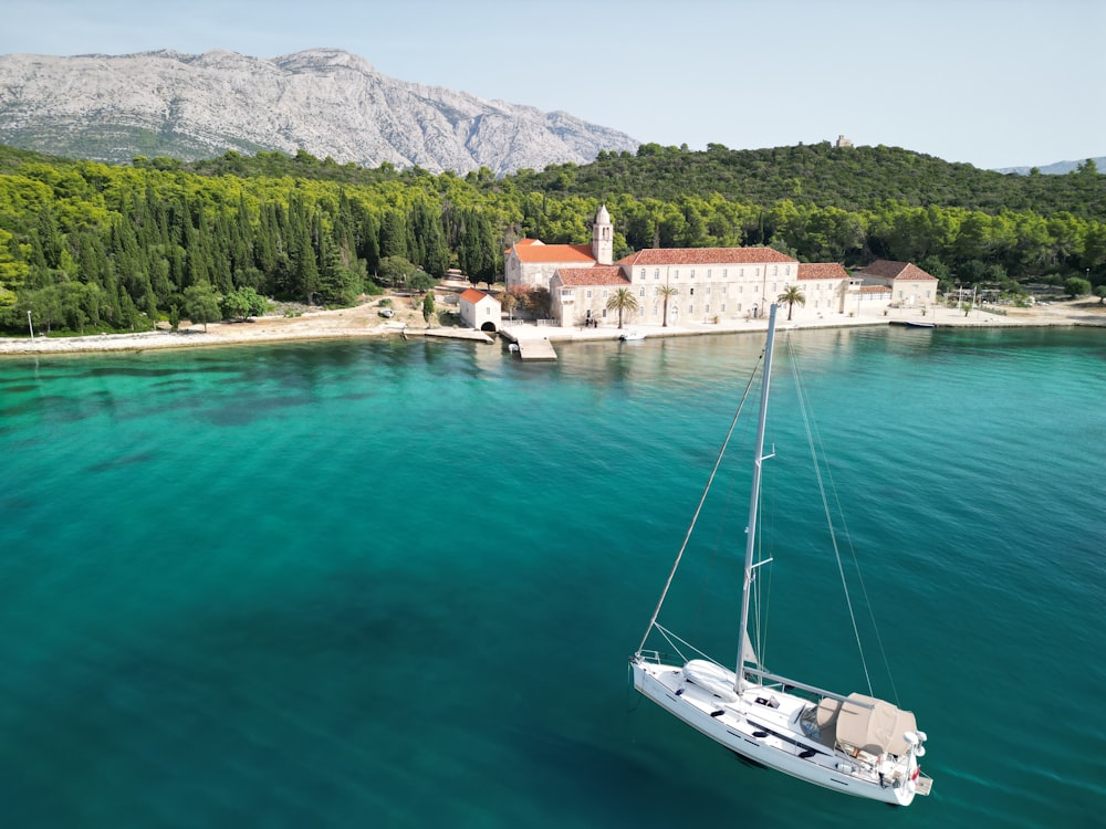 a sailboat in the water near a small island